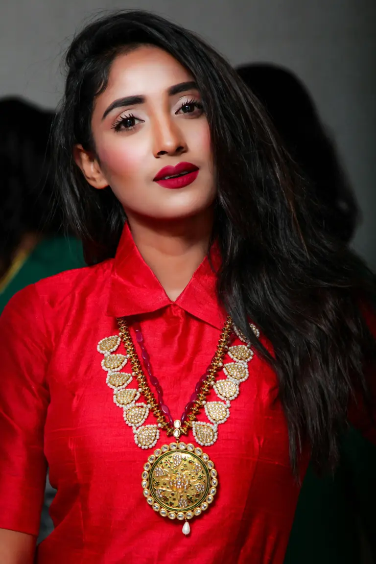 Portrait of a young woman in traditional attire with elegant jewelry and a confident pose.